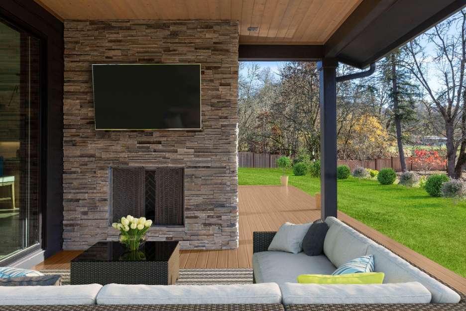 A covered outdoor living space with a stone fireplace, mounted TV, and patio seating overlooking a grassy yard.
