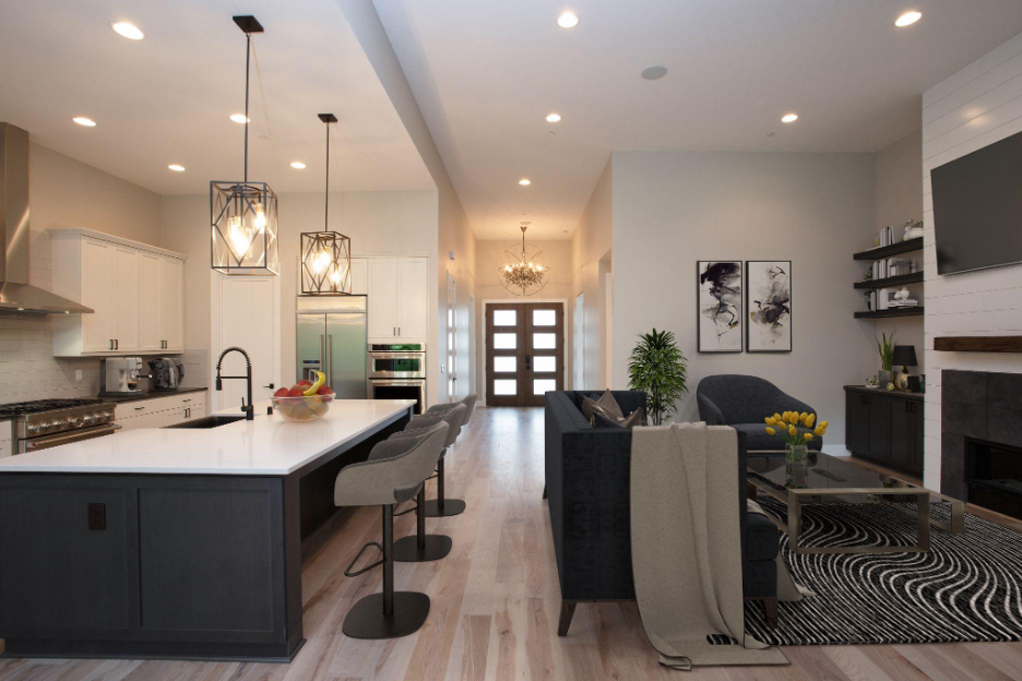 An open-concept kitchen and living area with pendant lighting, a large island, and modern furnishings.