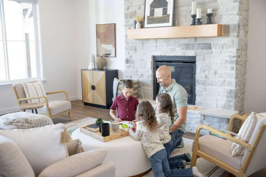 Family spending time together in a custom home living room with stone fireplace and modern furnishings.