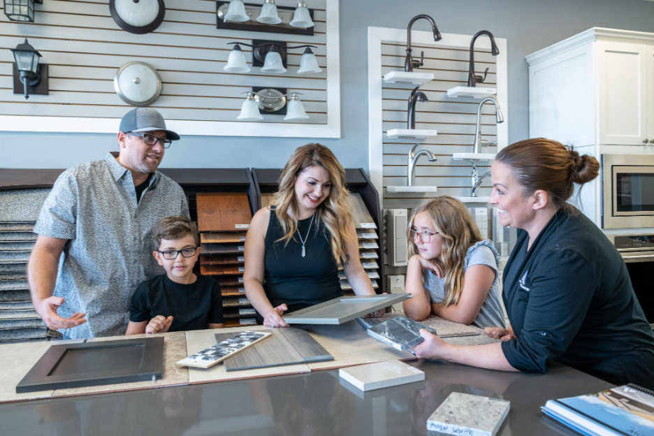 A family reviewing material samples with a design consultant inside a home design center.