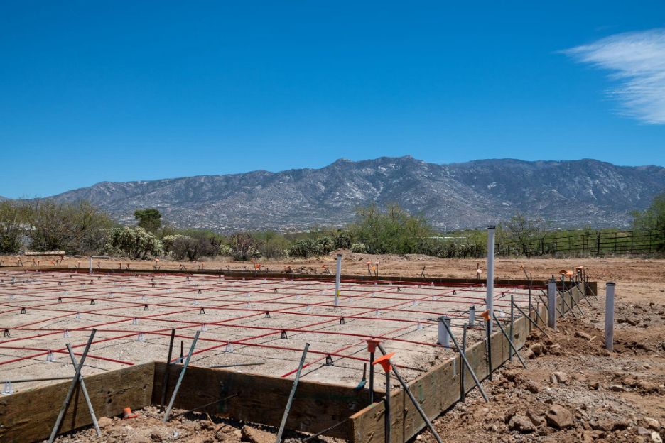 Custom home foundation and site preparation in Phoenix with rebar and concrete forms on desert land