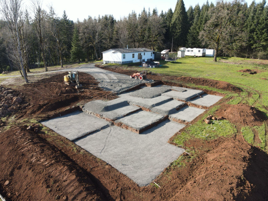 Custom home foundation and site preparation on a wooded lot with excavation and gravel base installed