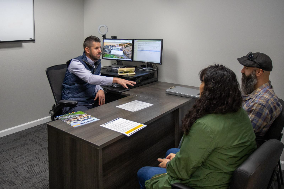 Homeownership counselor meeting with clients at an Adair Homes design center to review custom home plans