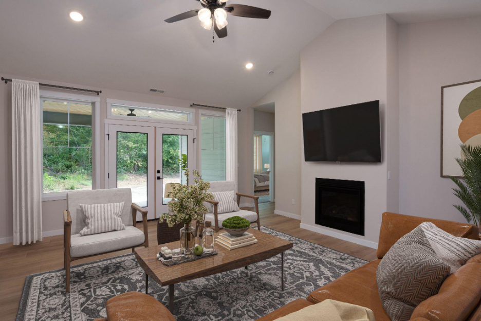 Cozy living room with fireplace, mounted television, French doors, and neutral modern furnishings.