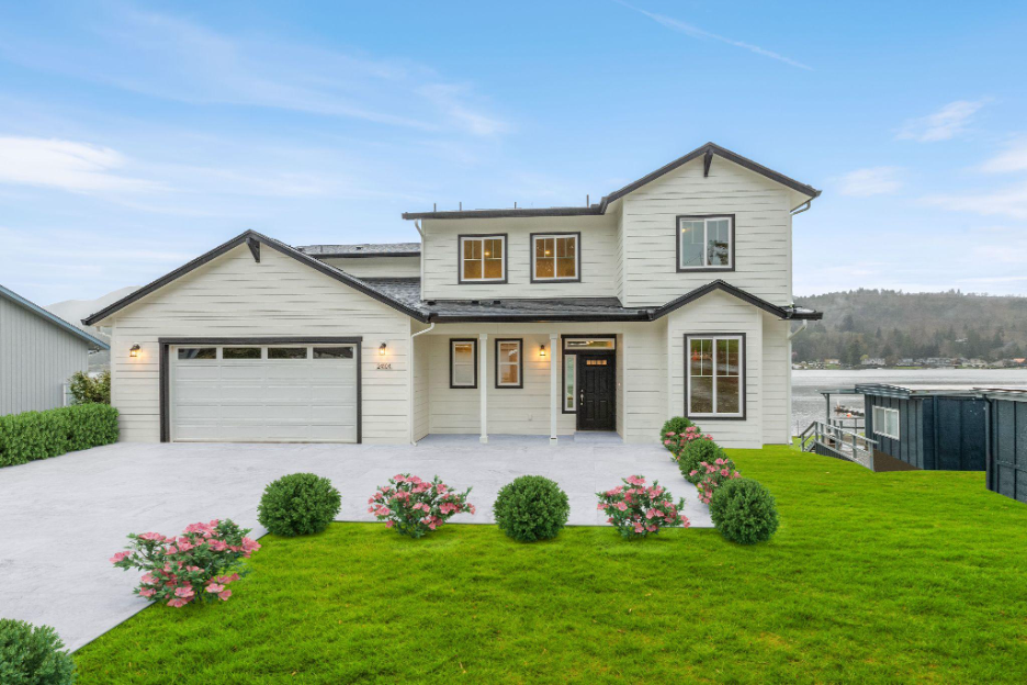Completed custom two-story home built on the homeowner’s land with landscaped yard and modern exterior