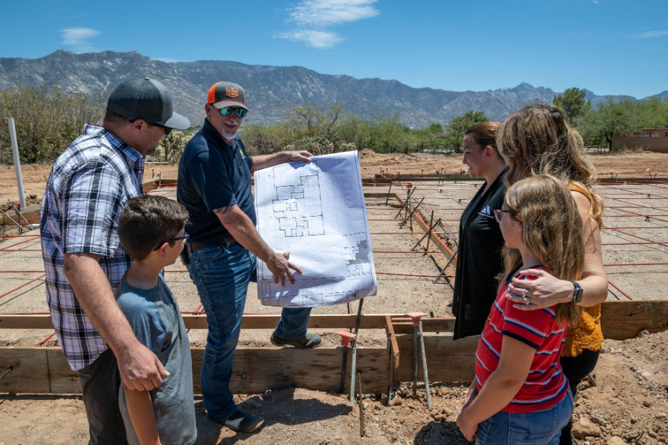 Adair Homes construction superintendent reviewing foundation plans with homeowners on their land