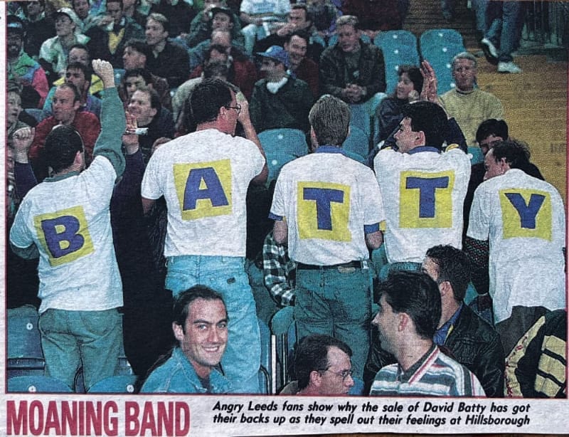 A photo cut from the papers at the time, of unhappy Leeds fans in the away end at Hillsborough turning their backs to show their white t-shirts each have a blue letter on a yellow square on the back — spelling out B-A-T-T-Y