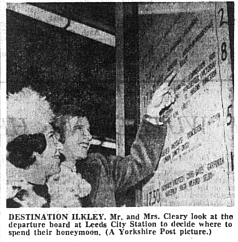 DESTINATION ILKLEY. Mr. and Mrs. Cleary look at the departure board at Leeds City Station to decide where to spend their honeymoon. (A Yorkshire Post picture.)