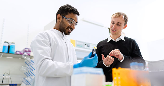 Two men perform what I think is probably science