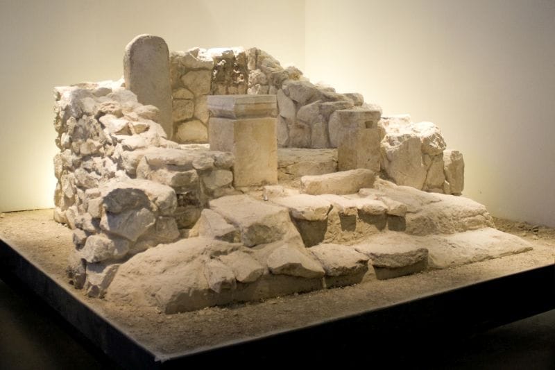 Reconstructed inner shrine of the Iron Age temple at Arad showing a niche with two upright standing stones and two small stone incense altars on a raised step, from a Judahite Yahweh temple.