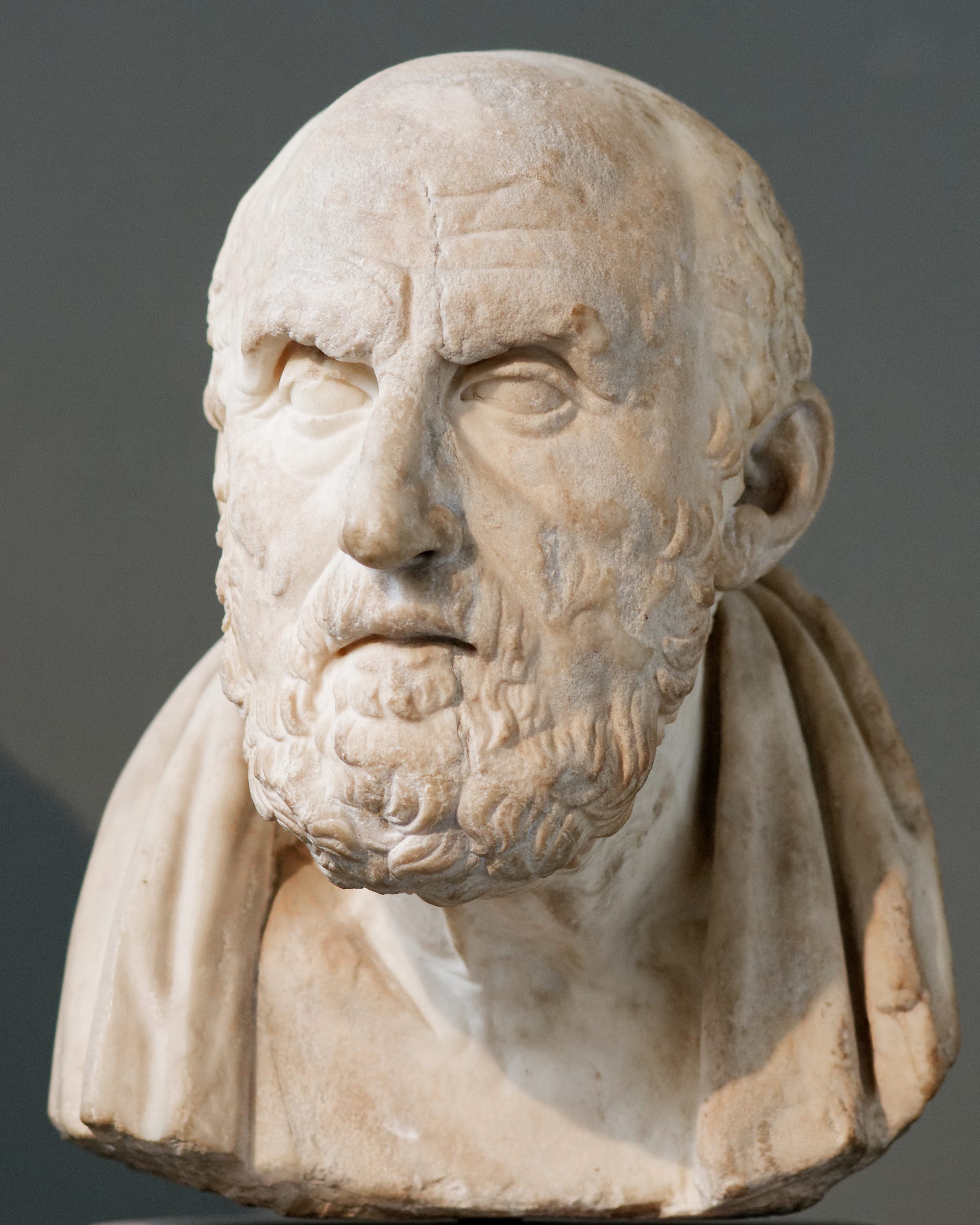 Ancient Roman marble portrait bust of a bearded Greek philosopher, head slightly bowed.