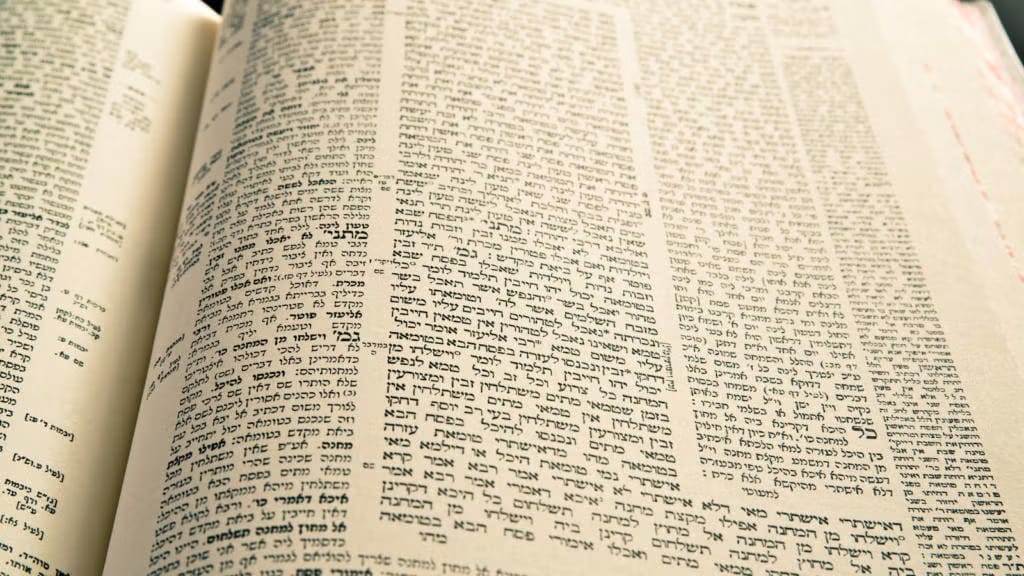 A printed Talmud page in Hebrew and Aramaic, a central block of text framed on all sides by concentric bands of smaller commentary.