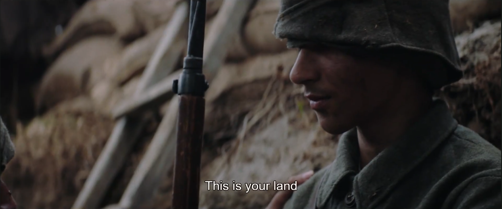 A still from We Are Still Here focusing on a Turkish soldier being told "This is your land"