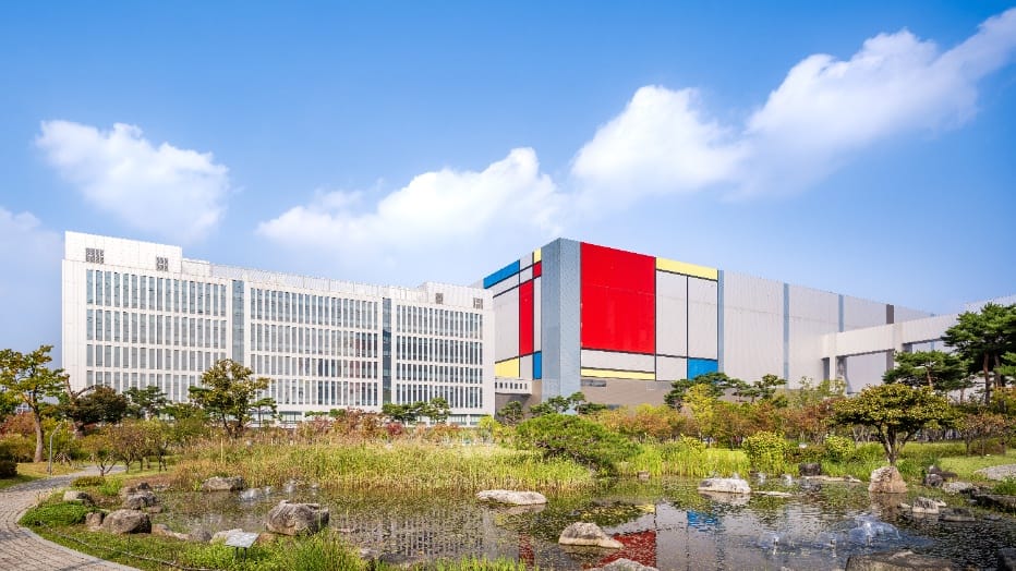Une usine du campus Samsung de Pyeongtaek, habillée de panneaux rouges, jaunes et bleus façon Mondrian, à côté d'un bâtiment de bureaux