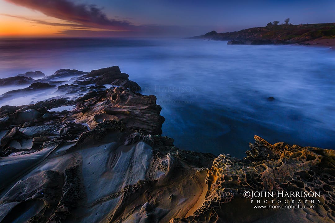Long exposure sunset seascape at Bean Hollow State Beach near Half Moon Bay, California featuring dramatic tafoni rock formations and silky ocean water along the Northern California coastline.