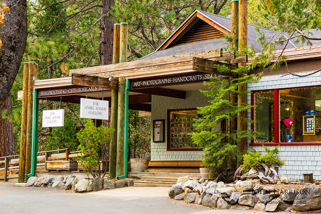 Exterior of The Ansel Adams Gallery in Yosemite Valley with signs for photography and art, a popular winter stop for visitors in Yosemite National Park.