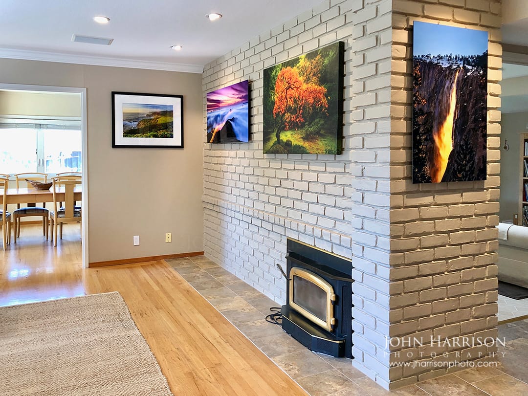 Residential fine art photography wall display featuring Yosemite Firefall at Horsetail Fall on El Capitan, Golden Gate Bridge in fog at sunrise, and Big Sur’s Bixby Bridge, shown as framed prints, HD acrylic, and canvas in a home interior.