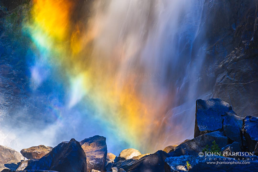 Winter rainbow in mist at Lower Yosemite Falls along the easy Yosemite Valley trail, a peaceful waterfall walk and one of the best things to do in Yosemite in winter.