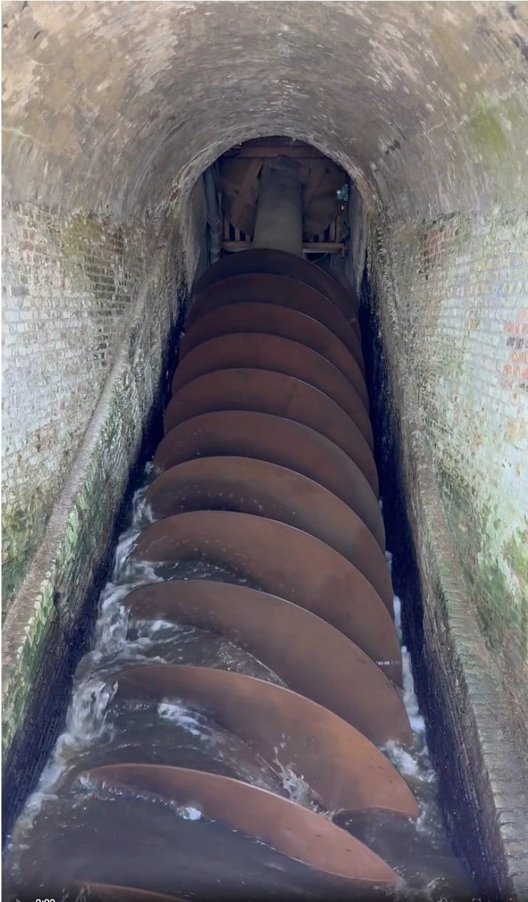 Massive wooden Archimedes’ screw inside the Aarlanderveen windmill in South Holland, Netherlands, part of the historic Dutch water management system still used to move water through the polder landscape.