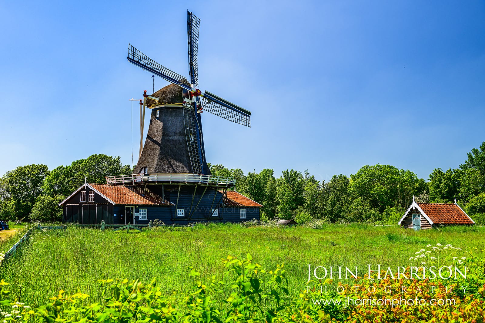 Bolwerksmolen wood sawmill windmill in Deventer Netherlands surrounded by green fields on a sunny day