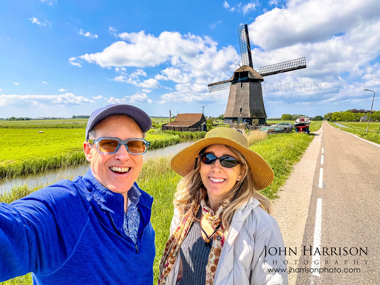 Photographer John Harrison standing with historic Ondermolen O windmill during National Windmill Day in Schermerhorn, North Holland Netherlands.