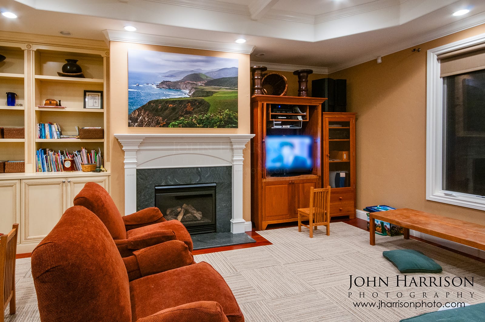 Large Big Sur coastline fine art photograph installed above a fireplace in a collector's living room showcasing California coastal wall art.