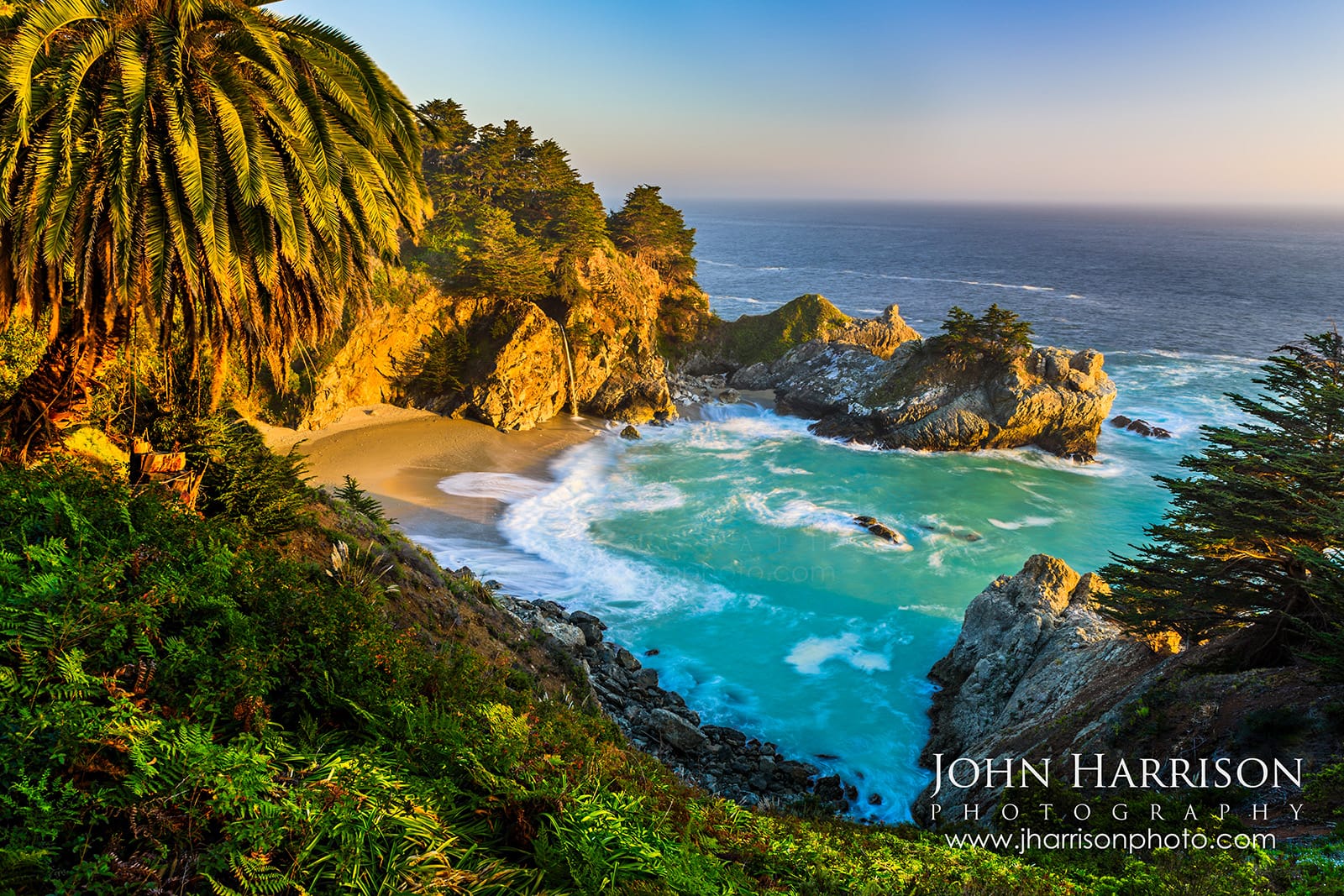 McWay Falls at sunset in Julia Pfeiffer Burns State Park, Big Sur California, with turquoise ocean water, coastal cliffs, palm tree, and waterfall flowing into the Pacific Ocean.