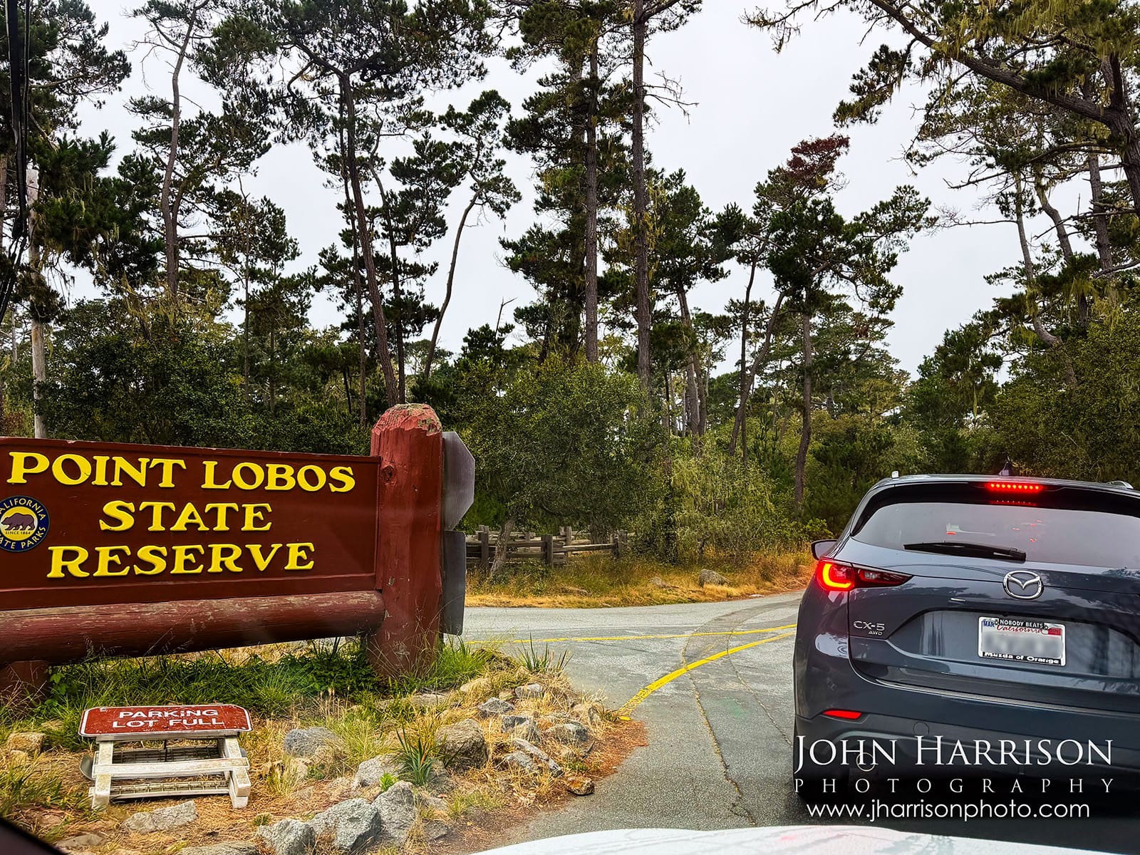 Traffic waiting at the Point Lobos State Natural Reserve entrance around 8:15 AM, with the Point Lobos entrance sign and a “Parking Lot Full” sign already positioned nearby.