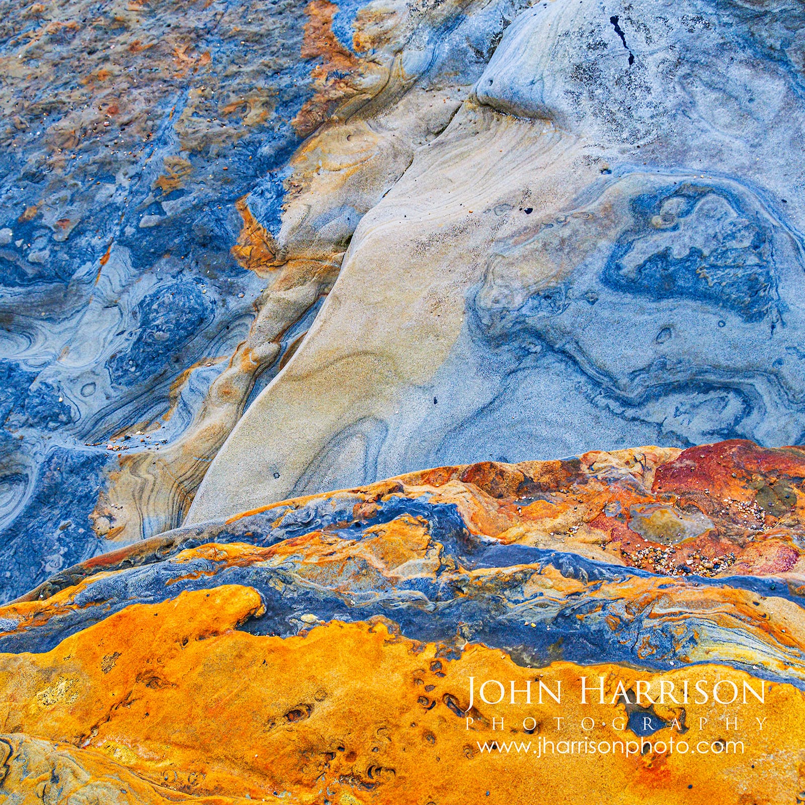 Square fine art photograph of natural blue, orange, rust and cream rock textures at Weston Beach in Point Lobos State Natural Reserve, California.