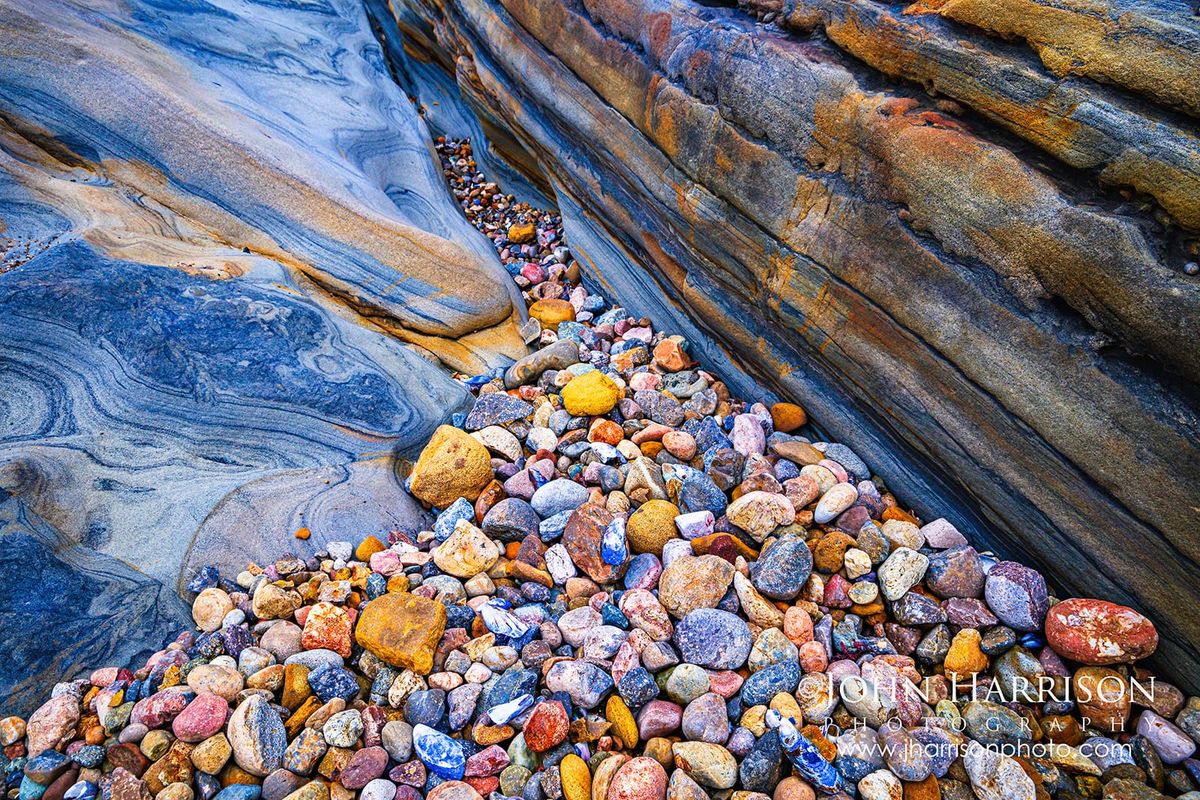Weston Beach in Point Lobos State Natural Reserve, featuring sculpted sandstone and colorful pebbles along California's Monterey Peninsula.
