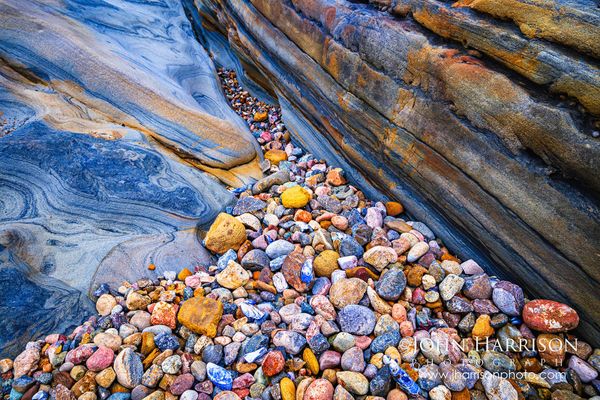Weston Beach in Point Lobos State Natural Reserve, featuring sculpted sandstone and colorful pebbles along California's Monterey Peninsula.