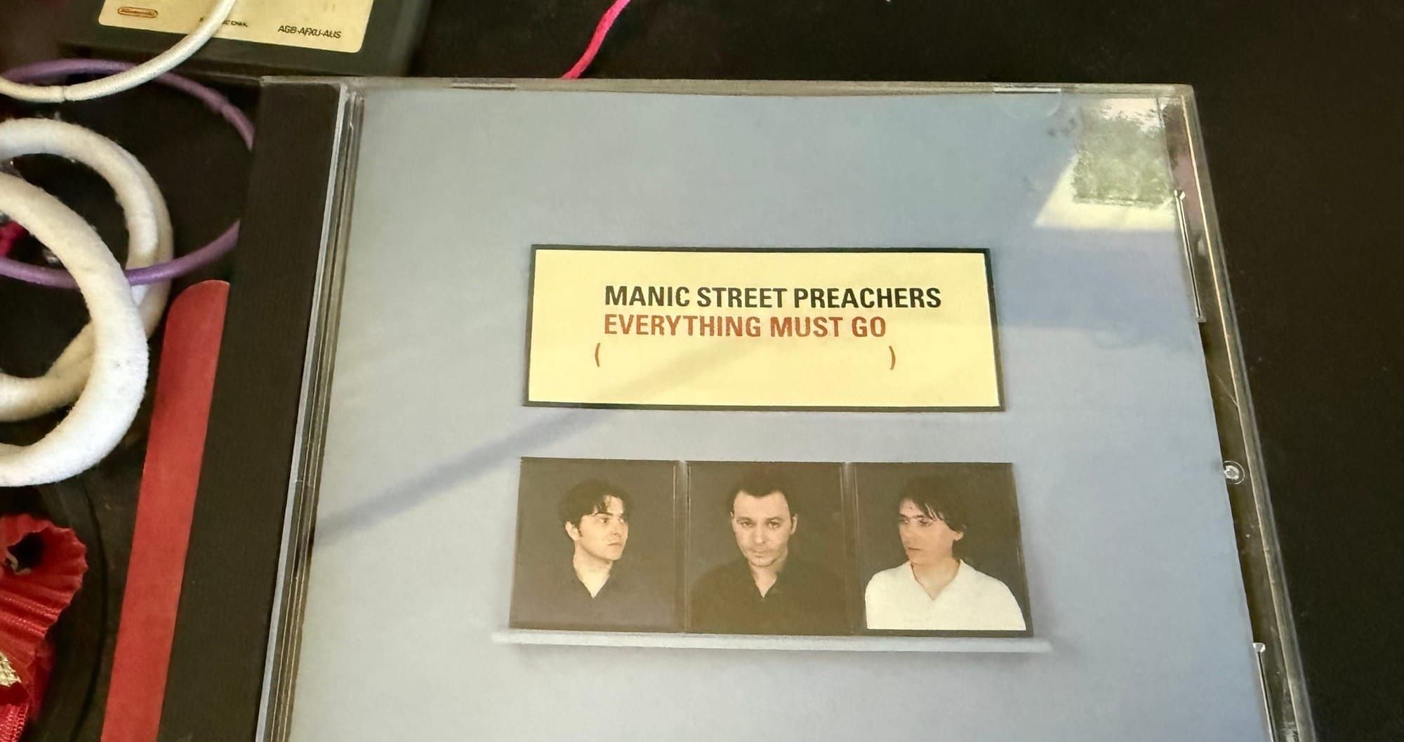 The CD of Everything Must Go by Manic Street Preachers sitting on a desk.