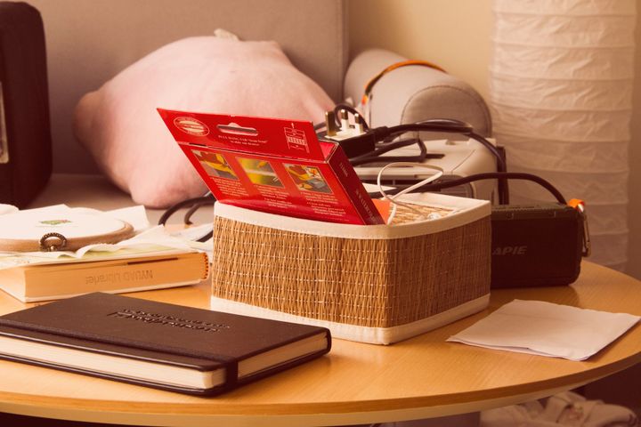 A photo of a small coffee table with a book, a notebook, some colored pencils, etc.