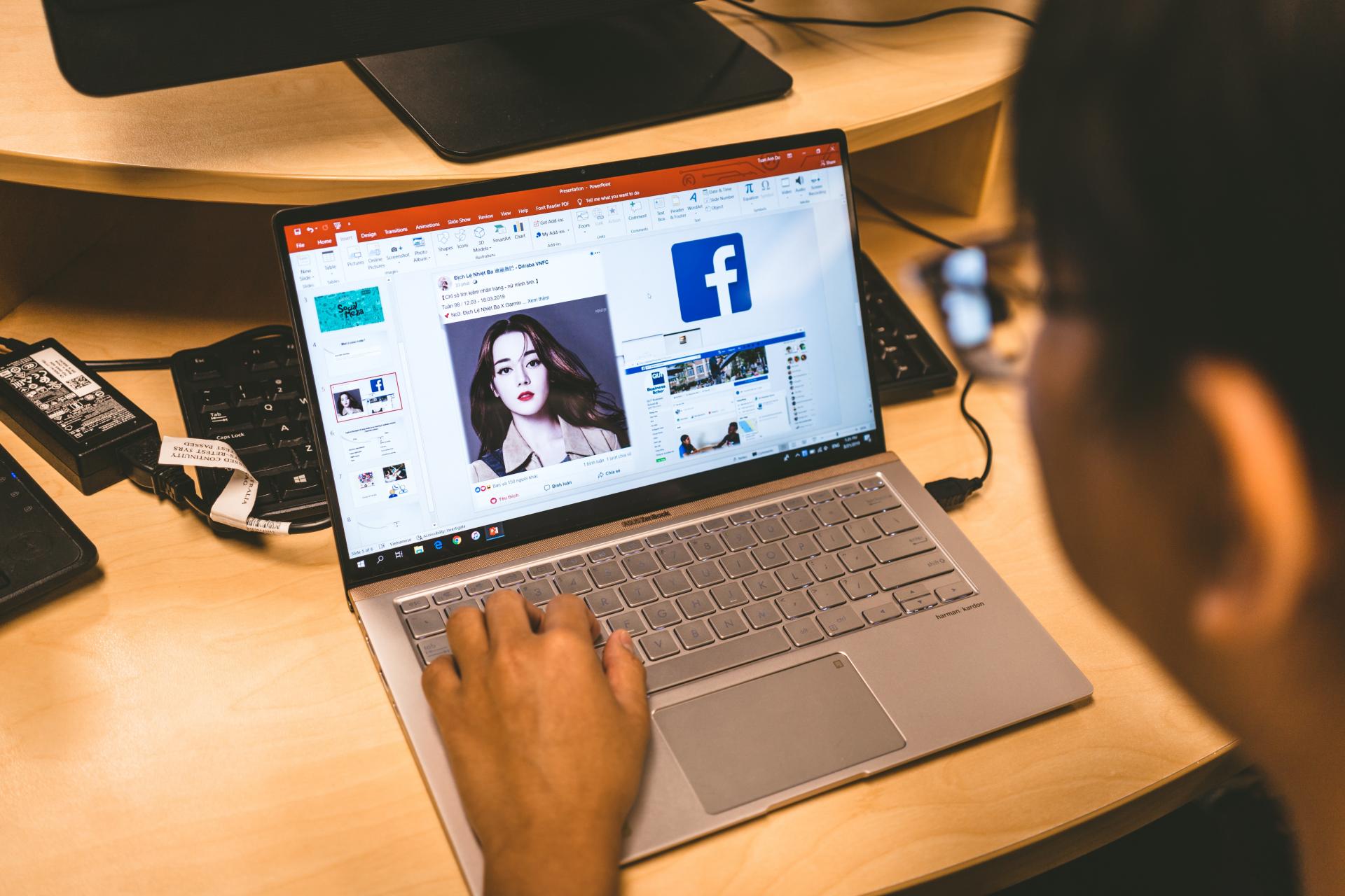person looking at facebook on a laptop