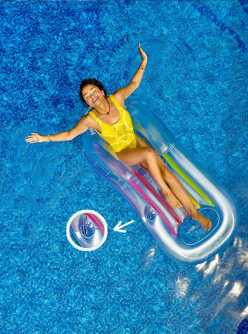 A woman lies in a lounger float with a built-in cup holder.