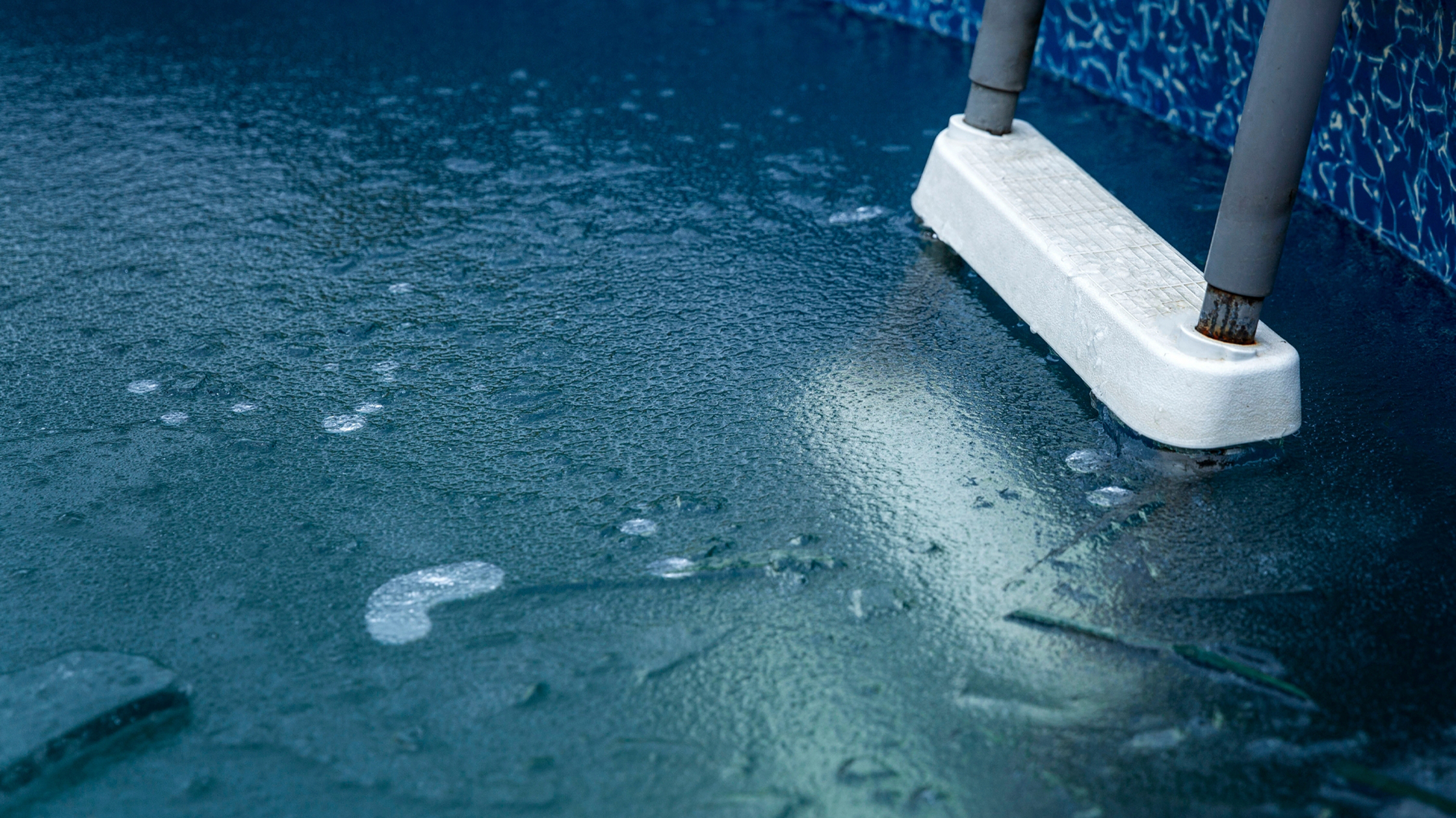 Pool water freezes on surface.