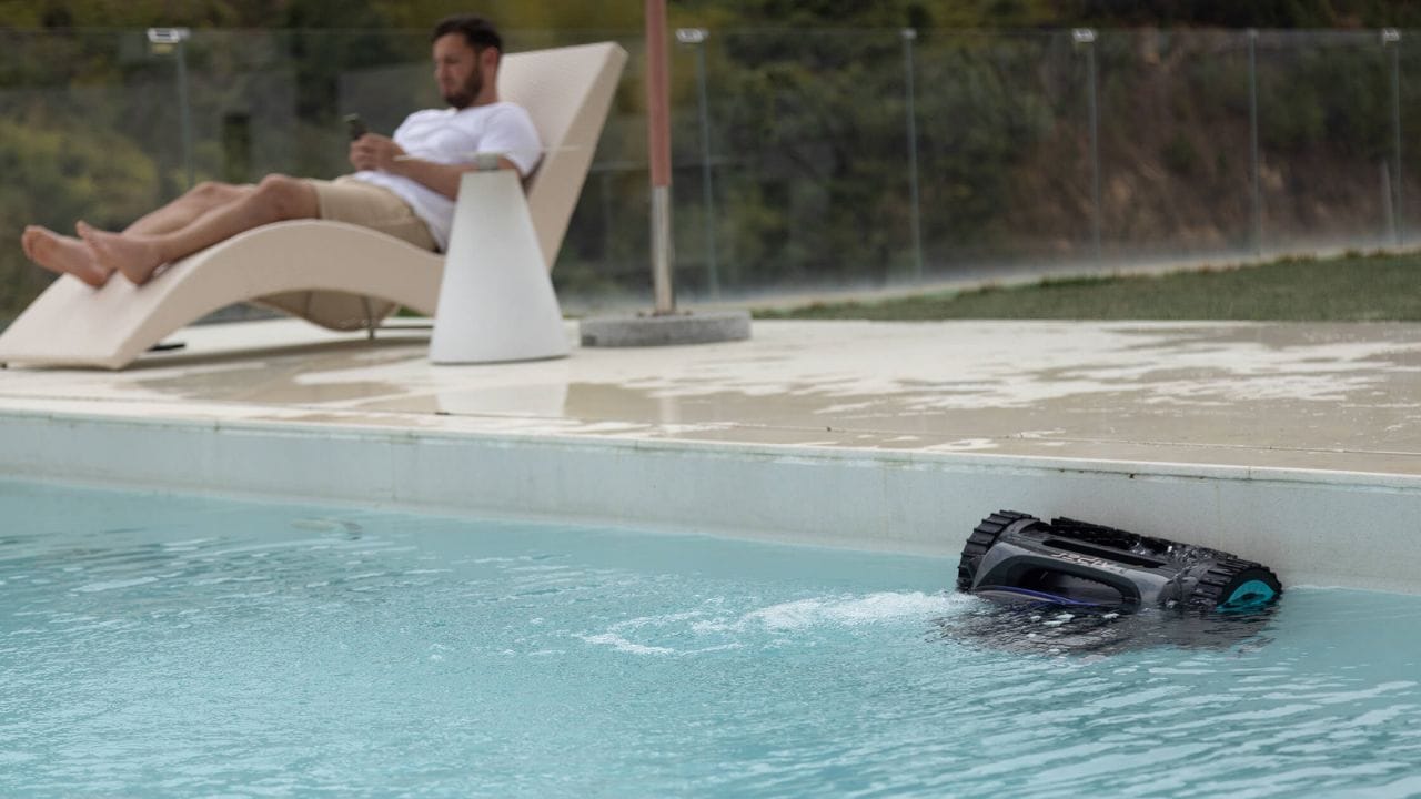 an automatic pool cleaner is cleaning the pool wall
