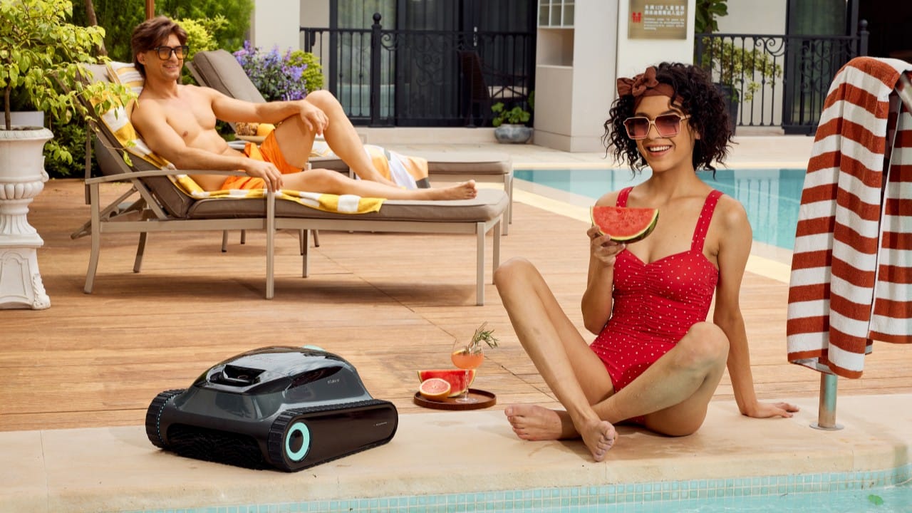 People relaxing by a clean pool with a robotic cleaner, showcasing automated maintenance benefits.