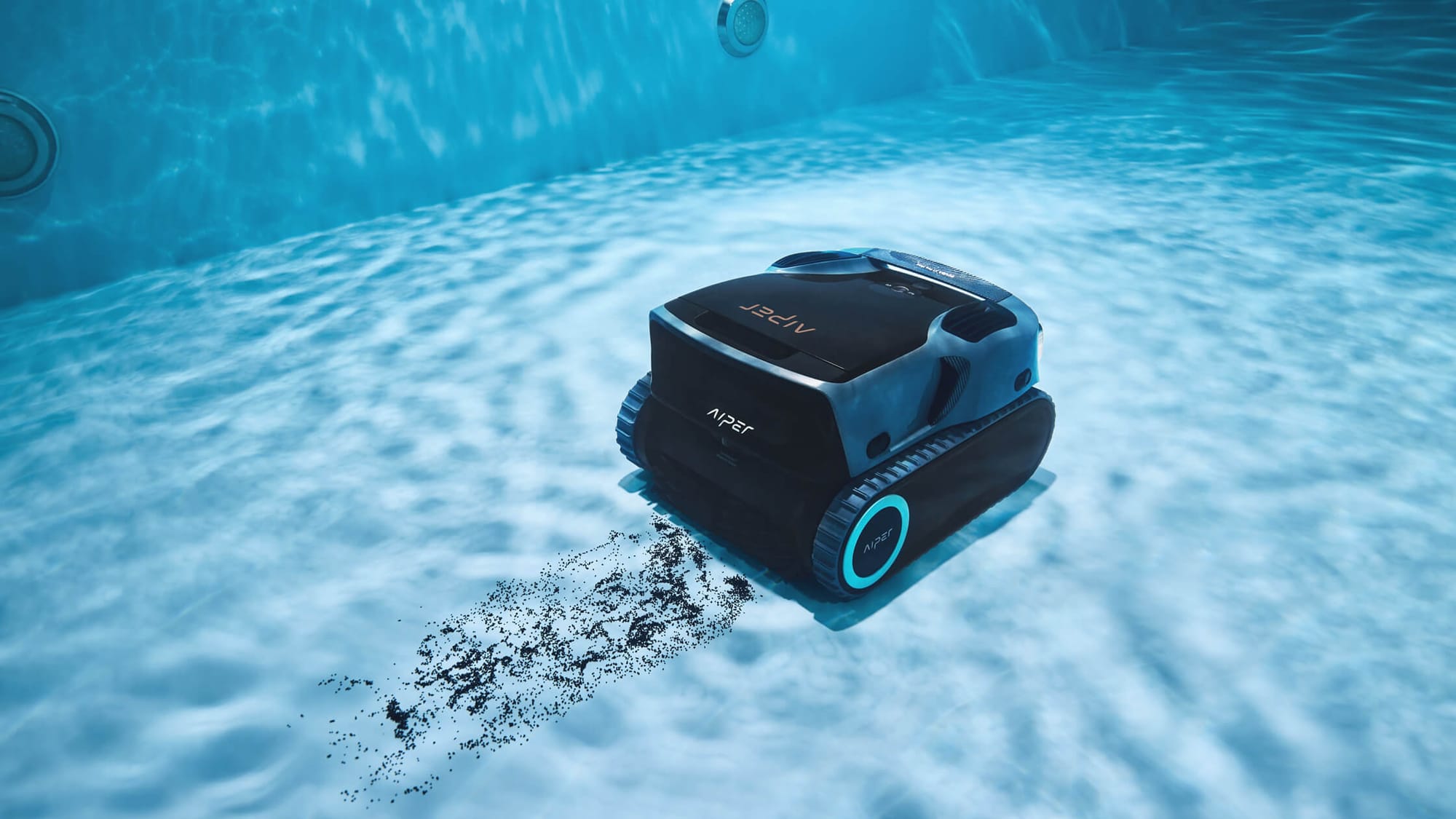 A robotic pool cleaner scrubs debris and dirt from the bottom of a clear blue swimming pool.
