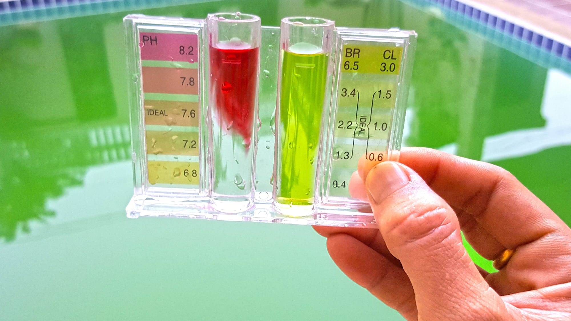 A person checking water chemistry with a test strip to maintain correct pH and chlorine levels in the pool.