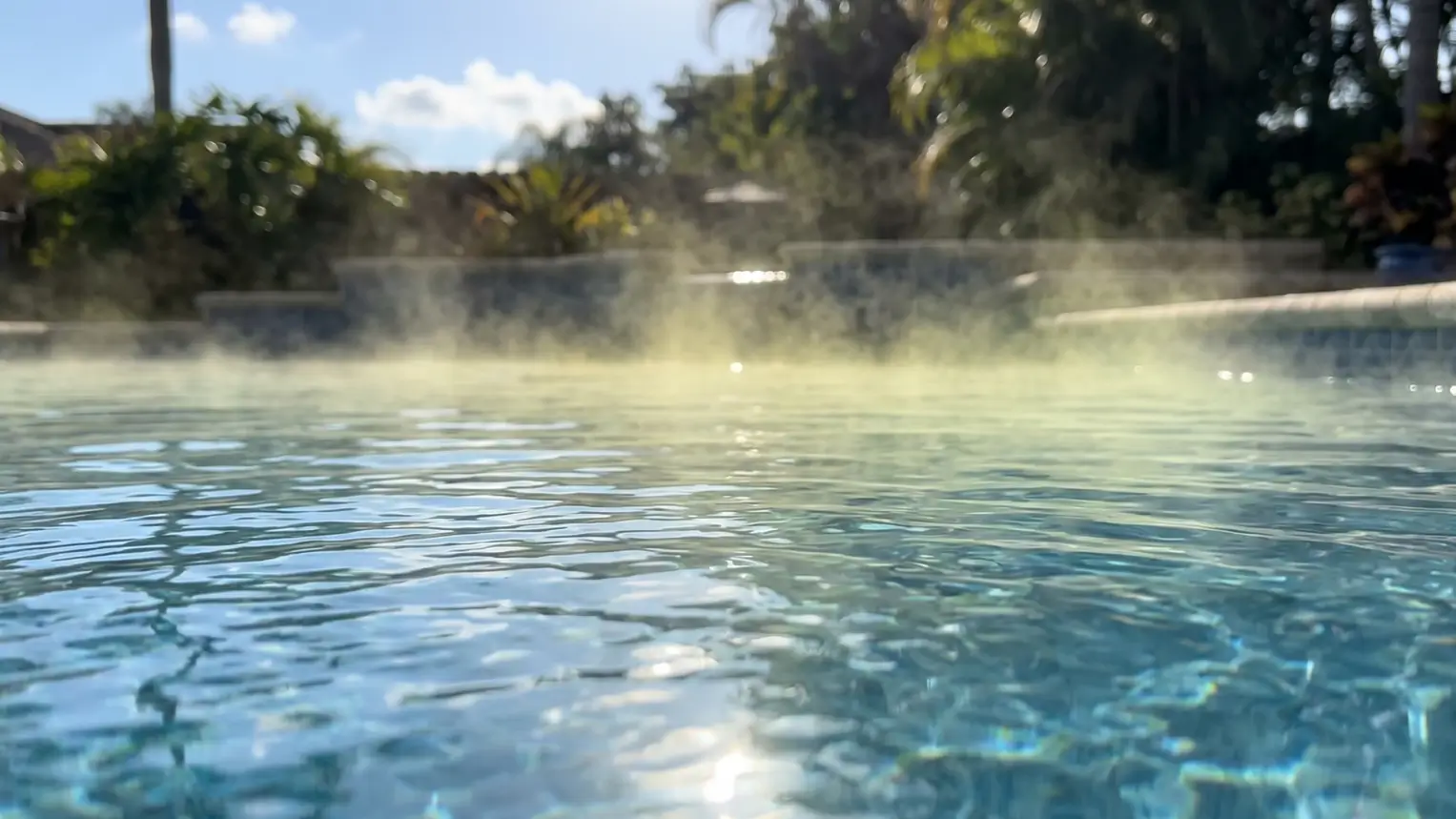 Thin chemical mist of chloramines hovering above pool water creating strong irritating odor.
