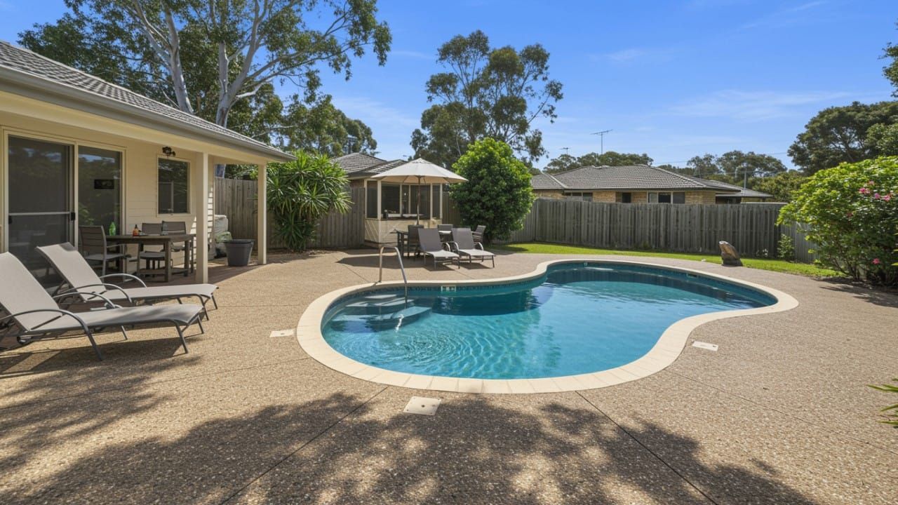 A sparkling clean pebblecrete pool in a sunny Australian backyard showing the results of proper maintenance.