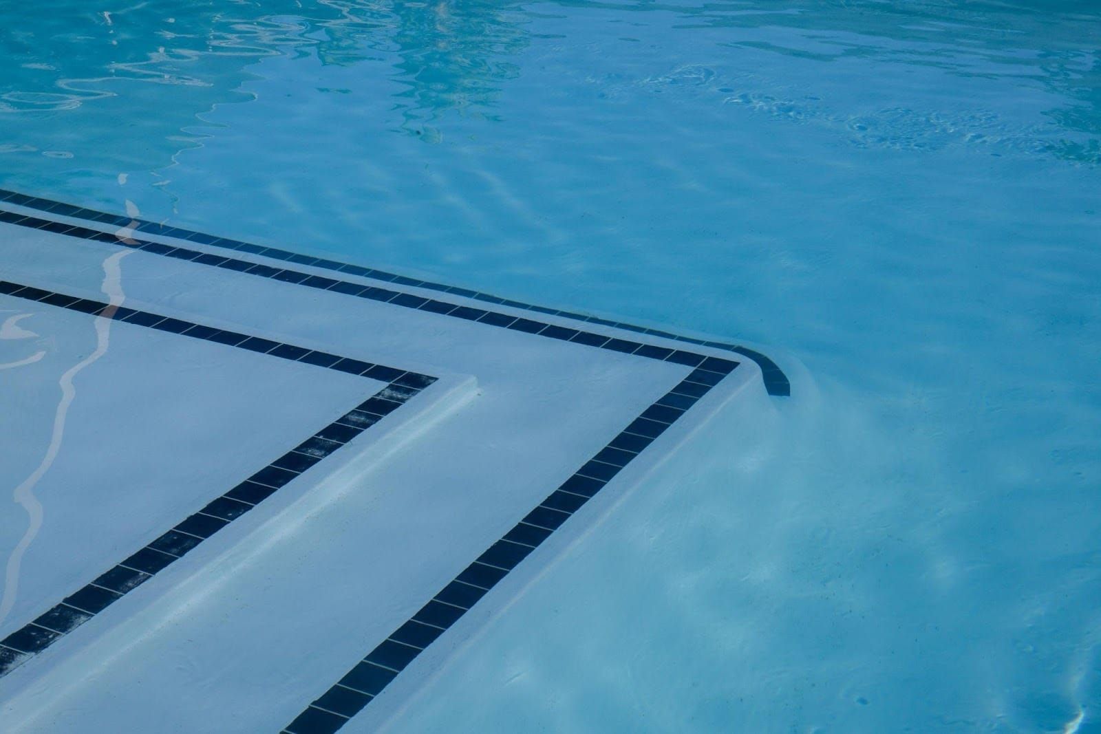 Marches de piscine avec du sable visible déposé au fond de la piscine