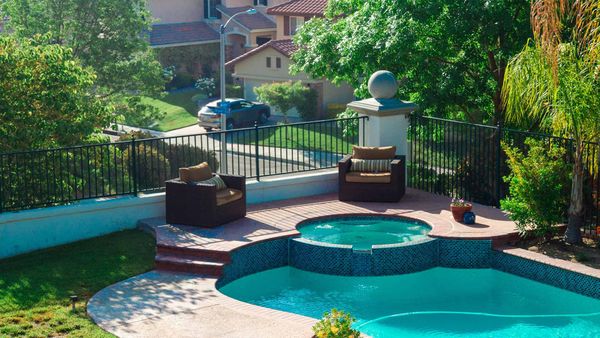 A beautiful backyard swimming pool and hot tub area, ready for a perfect spring and summer season after maintenance.