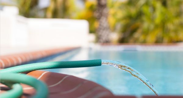 Soft water is injected into the swimming pool to lower the hardness of the water