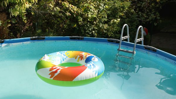 A colorful swimming ring floats in an above-ground pool