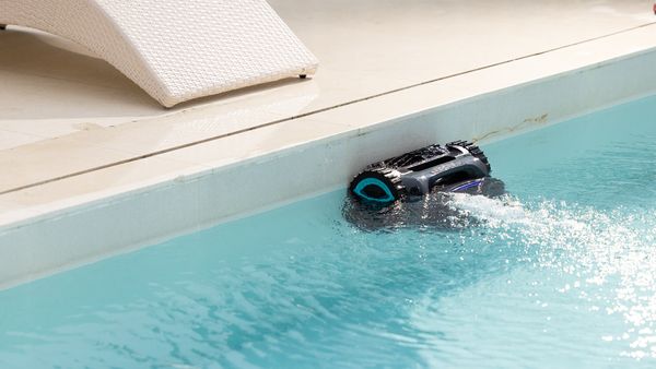 a robotic pool cleaner is cleaning the waterline on the pool wall