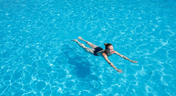 a crystal-clear blue swimming pool on a sunny day, representing the final result of using borax.