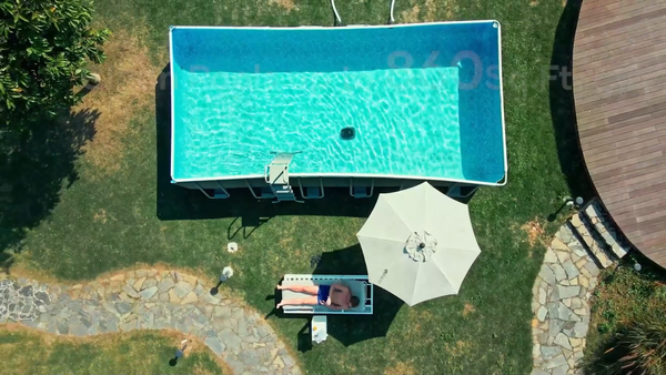 Piscine hors sol avec un robot de piscine et un homme se relaxant