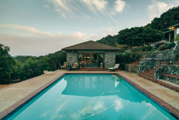 Piscina residencial rectangular con un limpiafondos de piscina con cable